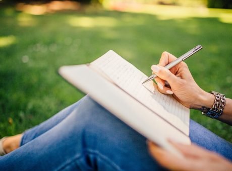 copywriters-woman-writing-in-a-notebook-at-the-park